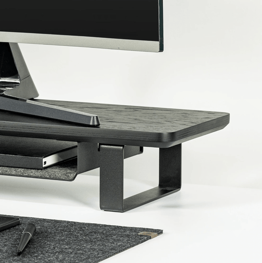 Black Monitoe Stand side angle shot with desk matt around